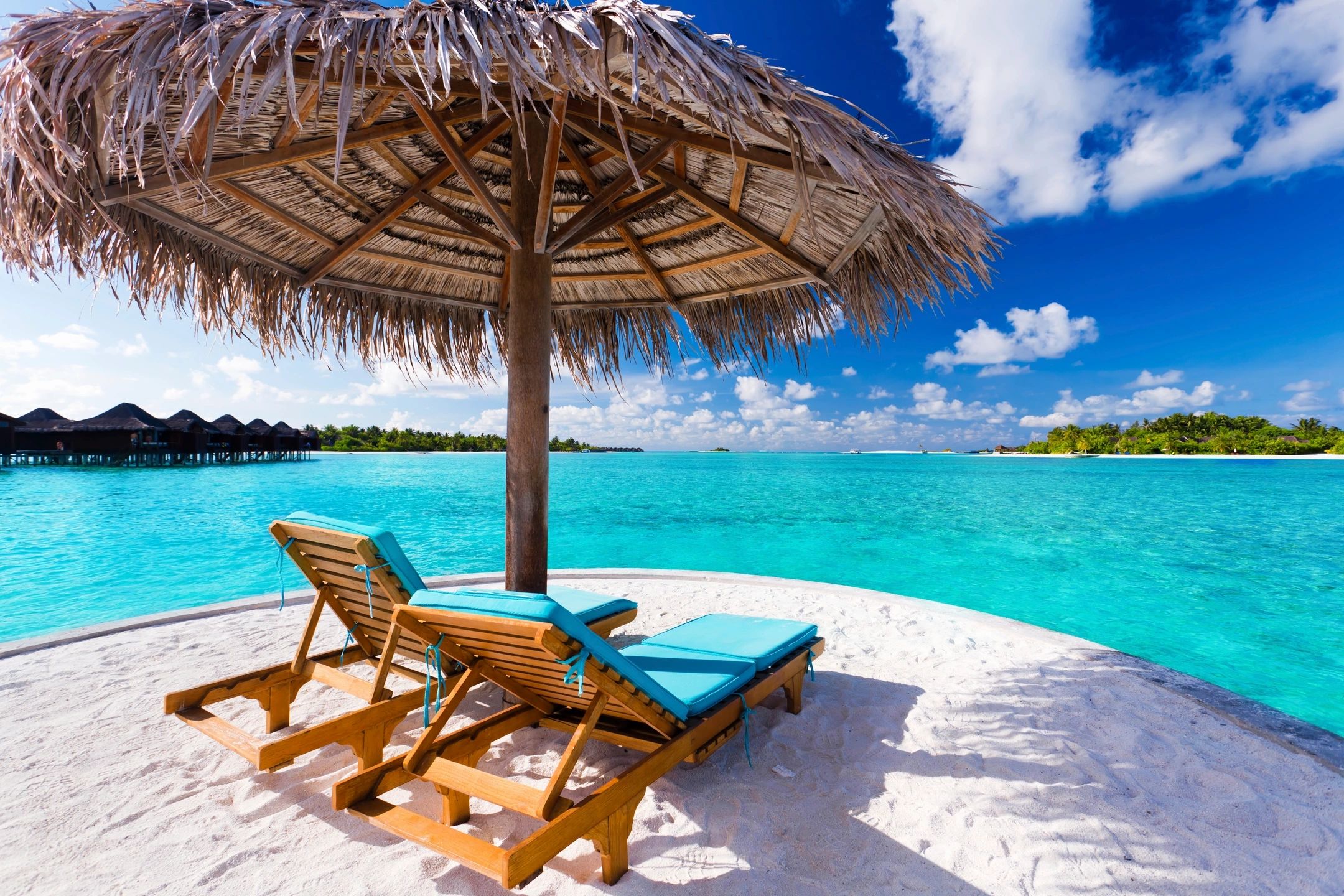 Beach lounge chairs white sand ocean